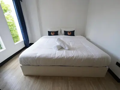 a bedroom with a bed with white sheets and pillows at RoomQuest IT Square Don Mueang Airport in Bangkok