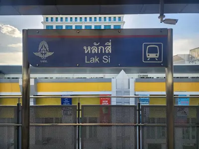 a sign for a train station with a building in the background at RoomQuest IT Square Don Mueang Airport in Bangkok