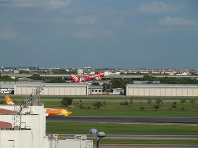 two planes are on the runway at an airport at RoomQuest IT Square Don Mueang Airport in Bangkok