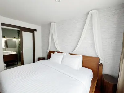 a bedroom with a white bed with a canopy at Homie Non - โฮมมี่ นนท์ in Ban Bang Khwang
