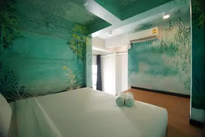a bedroom with a bed with two shoes on it at The Character Yaowarat เดอะคาแลตเตอร์ เยาวราช in Khlong San
