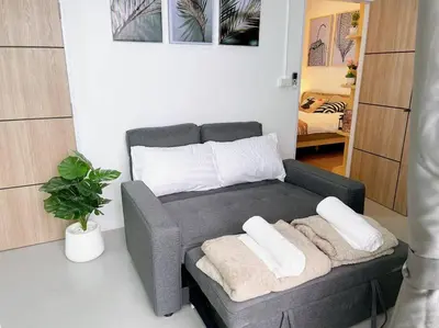 a living room with a couch with two pillows on it at Relax Private terrace&cozy BR,near Grand palace in Bangkok