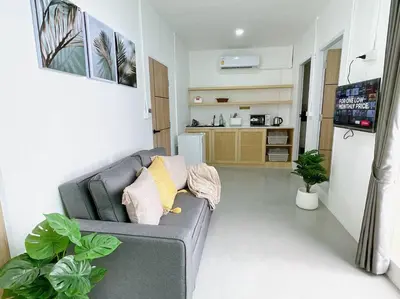 a living room with a gray couch and a tv at Relax Private terrace&cozy BR,near Grand palace in Bangkok