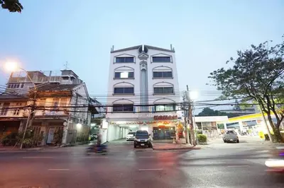 a tall white building with cars parked in front of it at Maruay Living Apartment 401 (Khaosan/Chinatown/Samyot MRT) in Bangkok