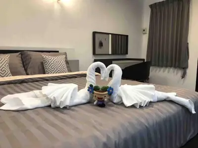 two swansuitsrendered to look like they are kissing on a bed at Maruay Living Apartment 401 (Khaosan/Chinatown/Samyot MRT) in Bangkok