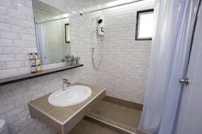 a white bathroom with a sink and a mirror at Maruay Living Apartment 510 (Khaosan/Chinatown/Samyot MRT) in Bangkok