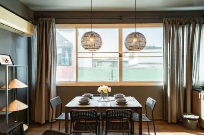 a dining room with a table and chairs and a window at Tuk Tuk House 250m from MRT Sirikit in Bangkok