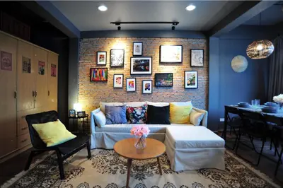 a living room with a couch and a brick wall at Tuk Tuk House 250m from MRT Sirikit in Bangkok