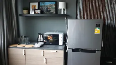 a kitchen with a refrigerator and a microwave on a counter at Tuk Tuk House 250m from MRT Sirikit in Bangkok