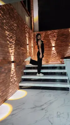 a woman standing on the stairs in a building at Irich residence South Samrong 6 Kms BTS-Pu Chao in Samut Prakan