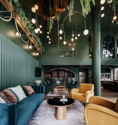 a living room with a blue couch and chairs at Cher Hostel Bangkok in Bangkok
