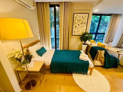 a bedroom with a bed and a yellow lamp at Cozy Spacious 1BR 2Bed GardenView 500m BTS Thonglo, Samitivej, SKV49, Rooftop Pool, Fast 500mbps wifi in Bangkok