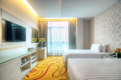 a hotel room with two beds and a flat screen tv at One One Bangkok in Bangkok