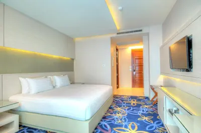 a bedroom with a white bed and a tv at One One Bangkok in Bangkok