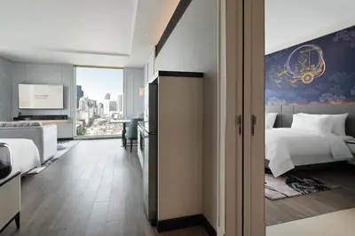 a hotel room with a bed and a large window at Grande Centre Point Surawong Bangkok in Bangkok