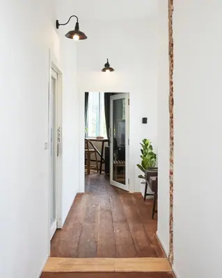 a hallway of a home with white walls and wood floors at Motu Bangkok in Bangkok