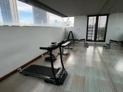 a gym with several treadmills in a room with large windows at W8 CONDO, TOP Floor LUXE 3 Bedroom Penthouse, Hip central Bangkok area, 5 mins from Thonglo BTS station in Bangkok