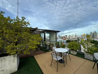 a balcony with a table and chairs and a view of the city at W8 CONDO, TOP Floor LUXE 3 Bedroom Penthouse, Hip central Bangkok area, 5 mins from Thonglo BTS station in Bangkok