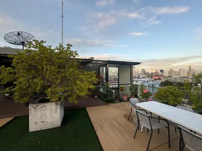 a balcony with a table and chairs on a roof at W8 CONDO, TOP Floor LUXE 3 Bedroom Penthouse, Hip central Bangkok area, 5 mins from Thonglo BTS station in Bangkok