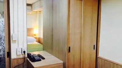 a room with a bed and a telephone on a desk at Sukhumvit 20 Guest House in Bangkok