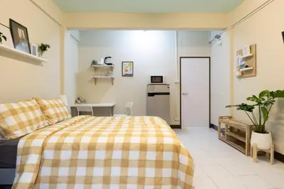 a bedroom with a bed with a checkered blanket at 204hideaway-Local Room with Street Food only 15 min walk to Skytrain in Bangkok