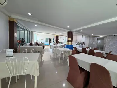 a restaurant with tables and chairs and white tables and chairs at Bed By Cruise Hotel At Samakkhi-Tivanont in Nonthaburi