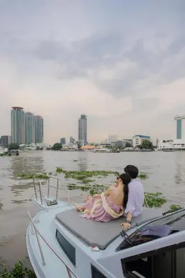 a man and a woman sitting on a boat in the water at Ten Six Hundred, Chao Phraya, Bangkok by Preference, managed by The Ascott Limited in Bangkok