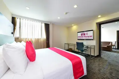 a hotel room with a large bed with red pillows at Hotel Royal Bangkok in Bangkok