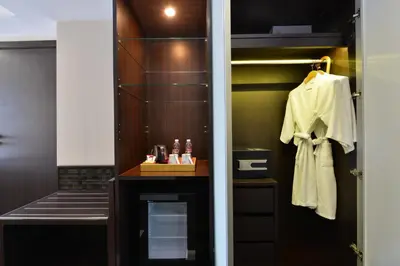 a bathroom with a closet with a white robe at Hotel Royal Bangkok in Bangkok