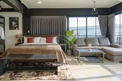 a bedroom with a bed and a couch at NORN Riverside Bangkok Hotel - นอนริมน้ำ in Bangkok
