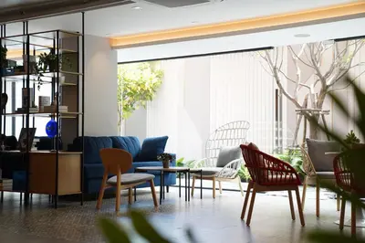a living room with chairs and a couch at View Place Hotel & Residence Lat Phrao 130 in Bangkok