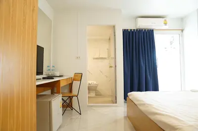 a bedroom with a bed and a desk with a computer at View Place Hotel & Residence Lat Phrao 130 in Bangkok
