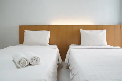 two beds with white sheets and towels on them at View Place Hotel & Residence Lat Phrao 130 in Bangkok