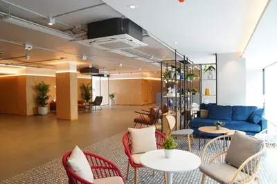 a lobby with a blue couch and tables and chairs at View Place Hotel & Residence Lat Phrao 130 in Bangkok