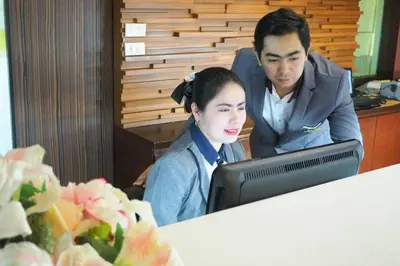 a man and a woman sitting in front of a computer at Happyland Mansion in Bangkok