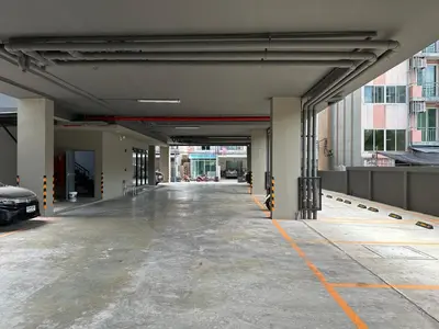 an empty parking garage with a car parked in it at D Night Suite Hotel in Bangkok