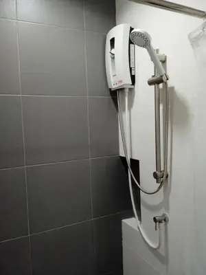 a shower head in a bathroom with a toilet at D Night Suite Hotel in Bangkok