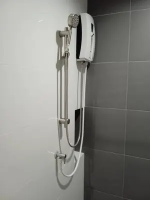 a shower in a bathroom with a phone on the wall at D Night Suite Hotel in Bangkok