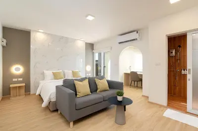 a bedroom with a bed and a couch and a table at Diya Hotel Bangkok in Amphoe Phra Khanong