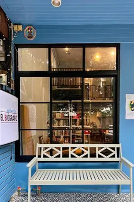 a white bench sitting in front of a store window at El Biografo in Bangkok