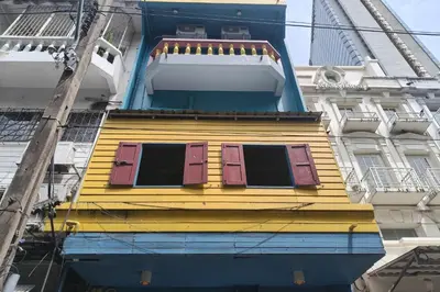 a yellow building with windows on the side of it at El Biografo in Bangkok