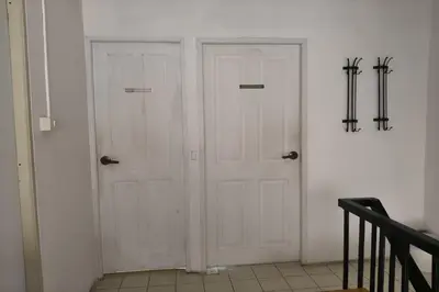 two white doors in a room with a staircase at El Biografo in Bangkok