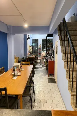 a dining room with a table and chairs and a staircase at El Biografo in Bangkok