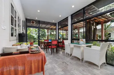 a dining room with a table and chairs and windows at Charlie House Pin Klao in Bangkok
