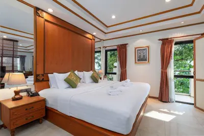 a bedroom with a large white bed with a wooden headboard at Charlie House Pin Klao in Bangkok