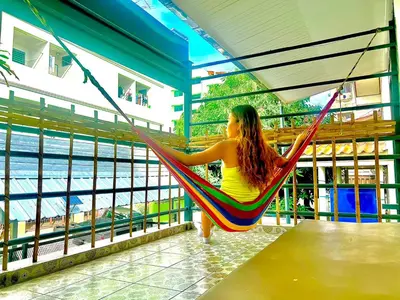 a woman sitting in a hammock looking at the water at Getaway Villa Bangkok - 4 Bedroom,6 Beds and 5 Bathroom in Bangkok