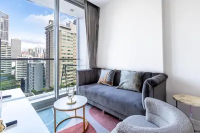 a living room with a couch and a large window at Hyde Sukhumvit 11 Branded Suites in Bangkok