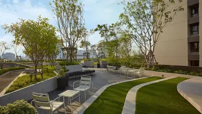 a garden with chairs and tables in a building at N Condominium in Ban Bang Khen (1)