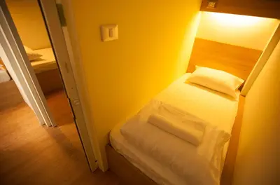 a small bedroom with a bed in a room at Micro Hostel in Bangkok
