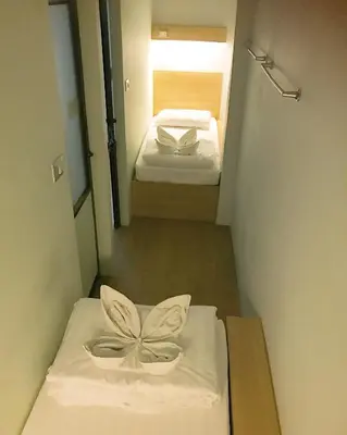 a small room with two beds and a bow on it at Micro Hostel in Bangkok